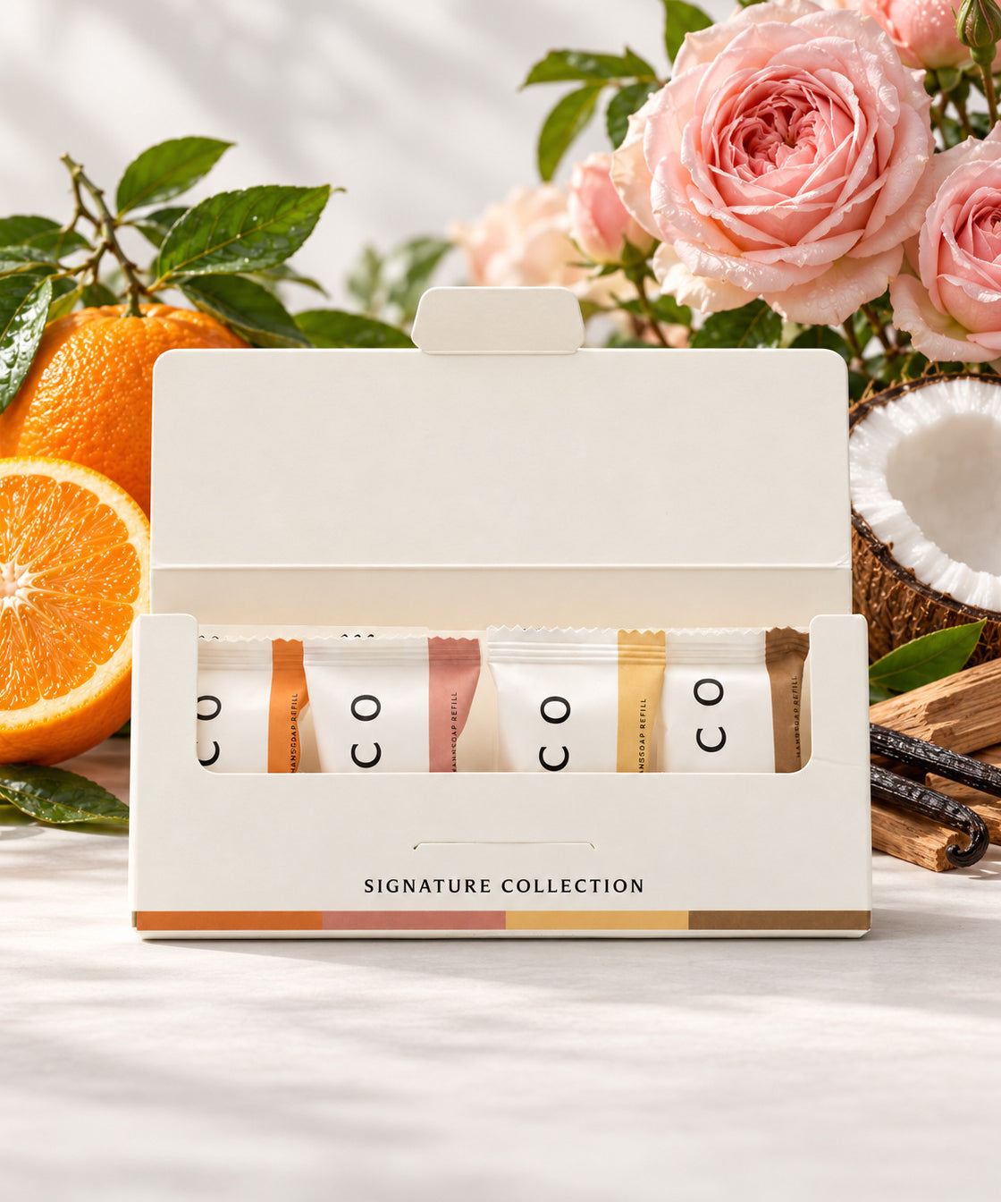 Elico håndsåpe refills 4-pakning Signature Collection, 1 av hver duft, åpen eske foran appelsin, roser, kokos og sandeltre