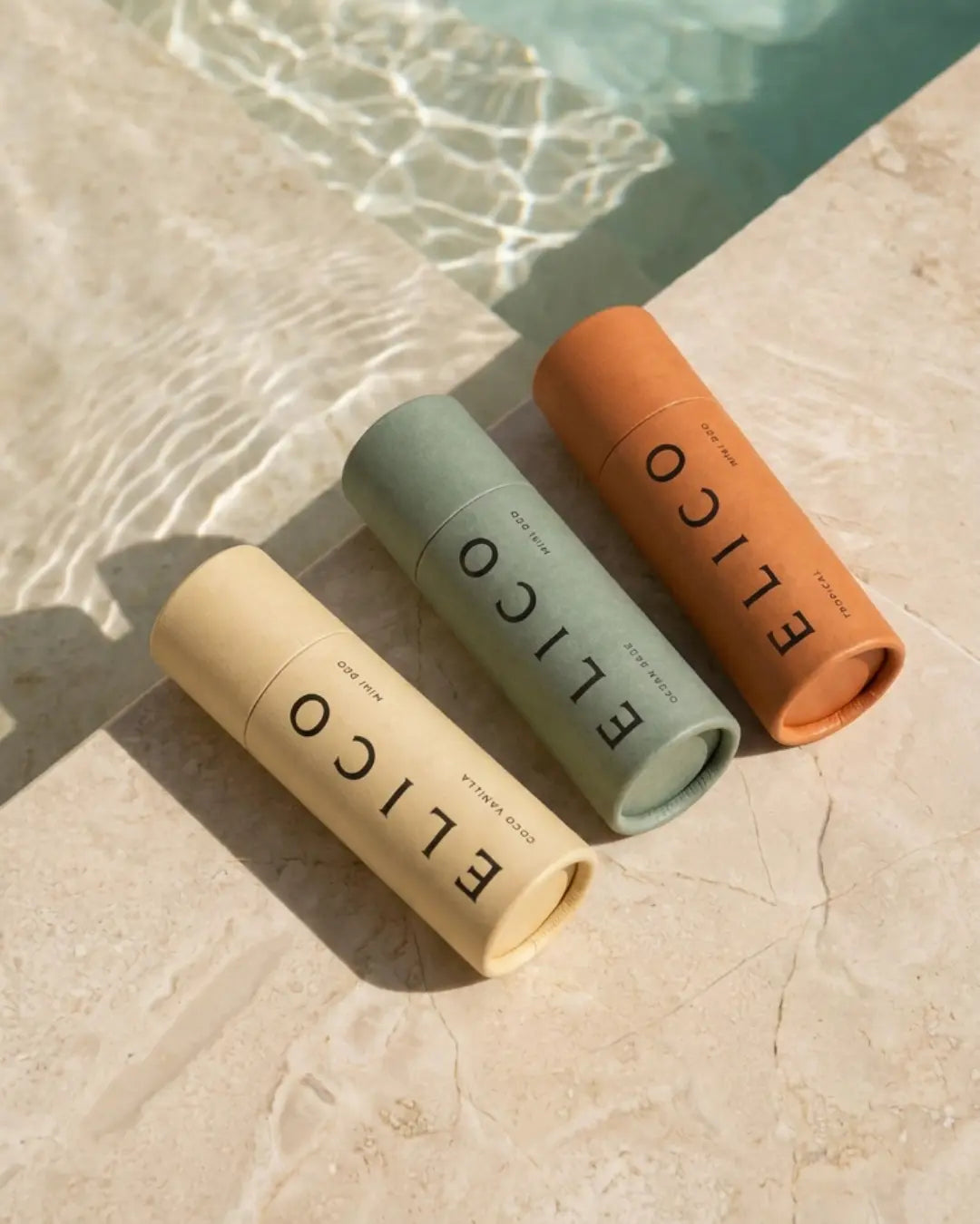 Tre Mini Deo-tuber i solljus vid en poolkant